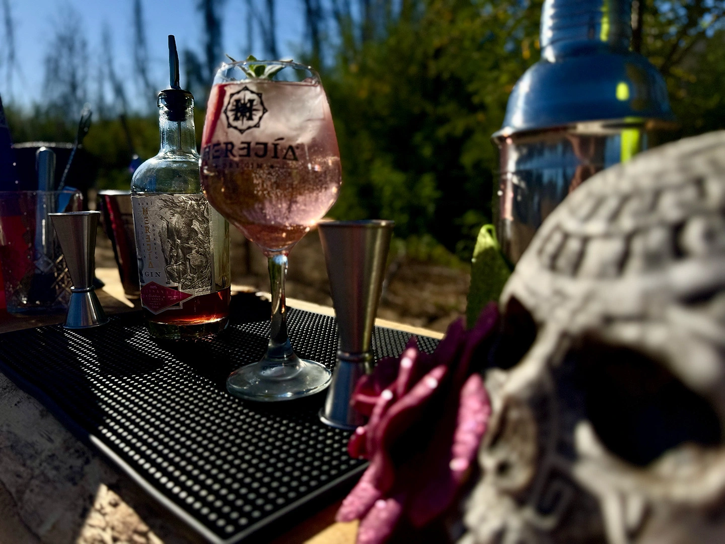 Receta gin tónica Ginxotic servida en copa premium Herejía, con fresas y hojas frescas, ideal para espíritus que buscan lo extraordinario.